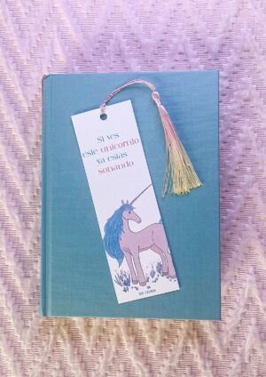 Marcapáginas de unicornio, en papel verjurado y decorados con borlines de colores variados, imagen sobre libro